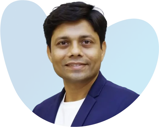 Portrait of a smiling man in a dark blazer against a blue background.